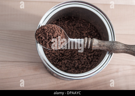 Paket von instant-Kaffee und Löffel über hölzerne Hintergrund öffnen Stockfoto