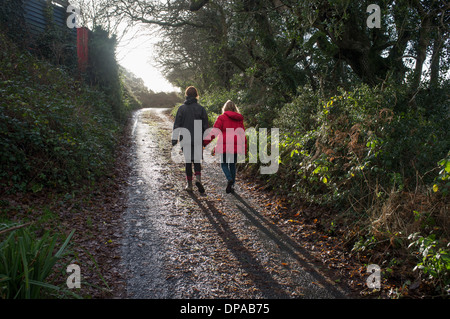 Eine Mutter und ihre Tochter zu Fuß entlang einer Gasse in Cornwall, Großbritannien Stockfoto