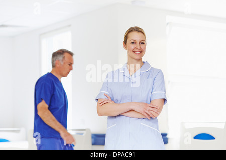 Porträt von Krankenschwester mit Arzt im Hintergrund Stockfoto