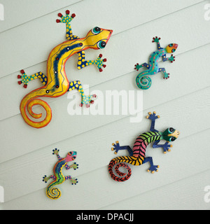 Bunte Gecko Dekorationen hängen an der Außenwand eines Hauses im Poolbereich Stockfoto