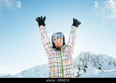 Porträt von Teenager-Mädchen-Skifahrer mit Arme angehoben, Les Arcs, Haute-Savoie, Frankreich Stockfoto