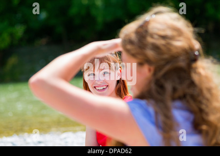 Zwei Freundinnen im Sonnenlicht, eine Abschirmung Augen Stockfoto