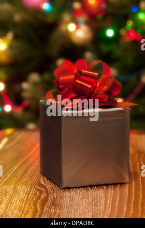 Silberne Geschenkbox mit rotem Band auf Weihnachten festlich Hintergrund Stockfoto