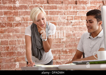 Zwei Kollegen an der Rezeption sprechen Stockfoto