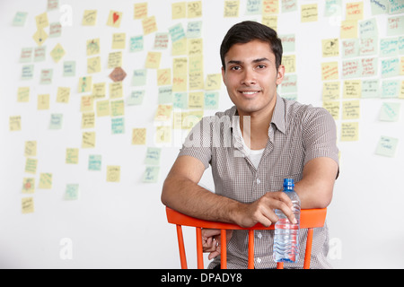 Porträt des jungen Mannes mit Klebstoff Noten im Hintergrund Stockfoto