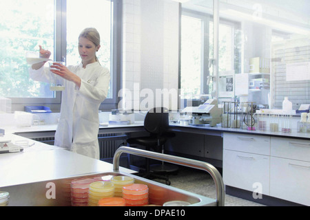 Wissenschaftler, die Mischen von Flüssigkeiten im Becher Stockfoto