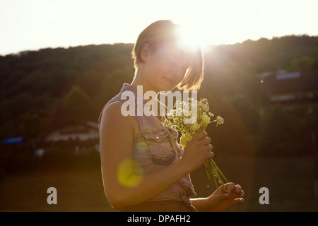 Junge Frau in Wiese mit wilden Blumen Stockfoto