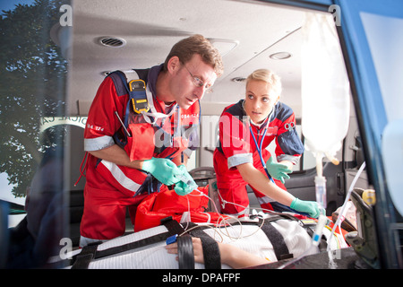 Sanitäter im Krankenwagen an Patienten arbeiten Stockfoto