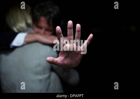 Reifer Mann Hand hochhalten, während Frau umarmt Stockfoto