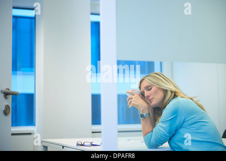 Müde Geschäftsfrau, die Überstunden im Büro Stockfoto