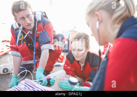 Gruppe von Sanitätern neigen Patienten unterwegs Stockfoto