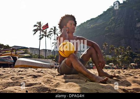 Mann am Strand mit Volleyball, Rio De Janeiro, Brasilien Stockfoto