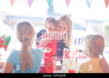 Zwei junge Schwestern trinken an Mutter und Bruder zu verkaufen Stockfoto