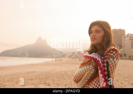 Junge Frau in Decke gehüllt, Strand von Ipanema, Rio De Janeiro, Brasilien Stockfoto
