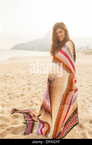 Junge Frau in Decke gehüllt, Strand von Ipanema, Rio De Janeiro, Brasilien Stockfoto
