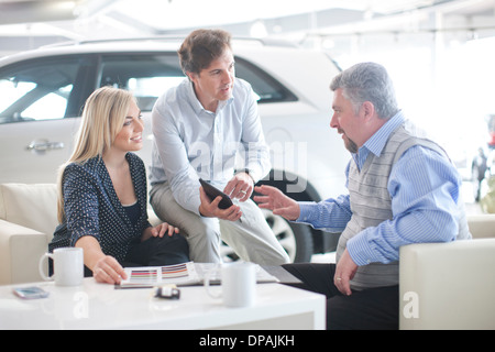 Im Gespräch mit paar im Autohaus Auto-Verkäufer Stockfoto