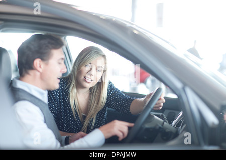 Auto Verkäufer beraten junge Frau im Autohaus Stockfoto