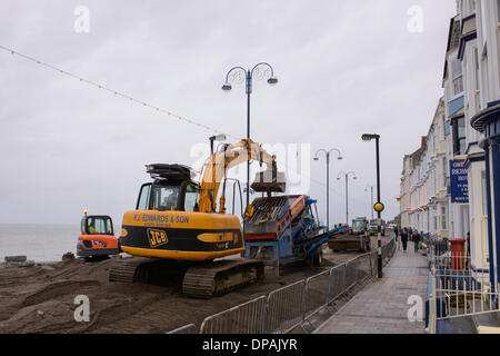 Aberystwyth, Wales, UK. 10. Januar 2014. Bereinigen und Reparaturarbeiten im Gange in Aberystwyth, Wales, 10. Januar 2014. Nach dem schweren Sturm und Brandung bei Aberystwyth in Wales, kostspieligen und umfangreichen reparieren und Aufräumen Arbeiten zur Wiederherstellung der Strandpromenade durchgeführt sind und Grad II aufgeführten Musikpavillon. Bildnachweis: Nigel Spooner/Alamy Live-Nachrichten Stockfoto