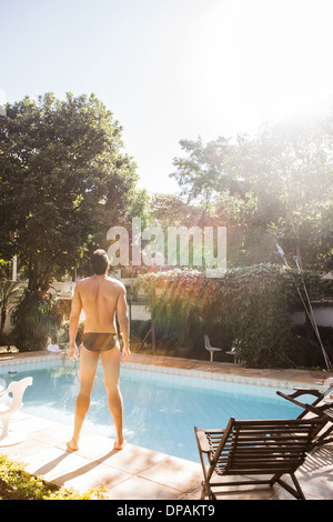 Mann, der in der Sonne am Pool Stockfoto