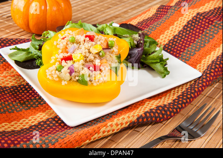 Gelbe Paprika gefüllt mit Quinoa und Gemüse mit grüner Feldsalat Stockfoto