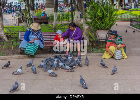 Drei Frauen und ein Baby, die füttert Tauben in der zentralen Plaza, Plaza 25 de Mayo, in Sucre, Bolivien. Stockfoto