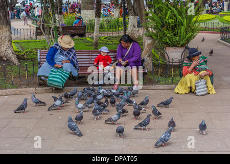 Drei Frauen und ein Baby, die füttert Tauben in der zentralen Plaza, Plaza 25 de Mayo, in Sucre, Bolivien. Stockfoto