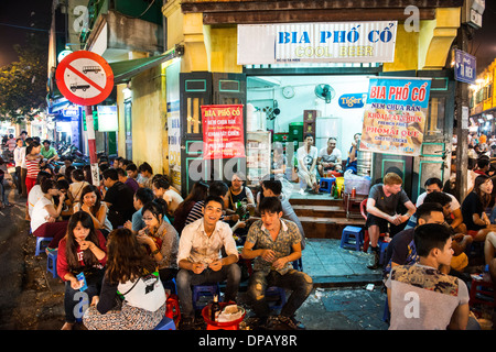 Touristen und Einheimische genießen Sie Bier vom Fass an der Bia Hoi Ecke in Hanoi, Vietnam. Stockfoto