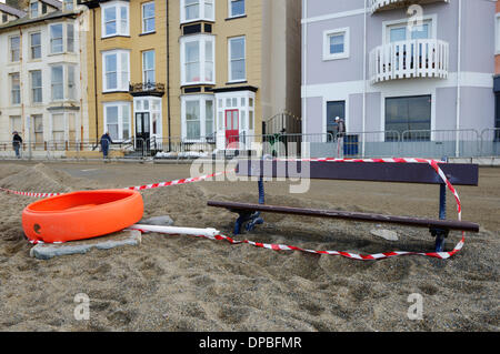 Aberystwyth, Wales, UK. 10. Januar 2014. Eine Woche nach einer schweren Sturmflut und Gale Winde zwingen beschädigt Aberystwyths Promenade, Schutt ist noch in der Gegend verstreut. Des Rates Arbeiter Klasse Flut Einlagen mit Maschinen, Sand und Pflastersteine zu trennen. Die Arbeit beginnt Abbau der Grade 2 öffentlichen Tierheim aufgeführt die Fundamente von denen am Meer untergraben wurden. Bildnachweis: Keith Burdett/Alamy Live-Nachrichten Stockfoto