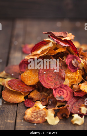 Gebratene Gemüse Chips gemacht von Pastinaken, süße Kartoffeln, rote Beete, Karotten und Rüben auf Holztisch Stockfoto