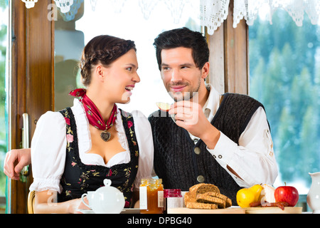 Paar in einer traditionellen Hütte mit einem herzhaften Frühstück Stockfoto