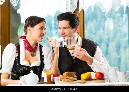 Paar in einer traditionellen Hütte mit einem herzhaften Frühstück Stockfoto