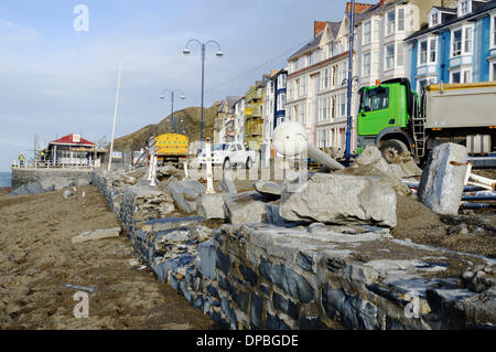 Aberystwyth, Wales, UK. 10. Januar 2014. Eine Woche nach einer schweren Sturmflut und Gale Winde zwingen beschädigt Aberystwyths Promenade, Schutt ist noch in der Gegend verstreut. Des Rates Arbeiter Klasse Flut Einlagen mit Maschinen, Sand und Pflastersteine zu trennen. Die Arbeit beginnt Abbau der Grade 2 öffentlichen Tierheim aufgeführt die Fundamente von denen am Meer untergraben wurden. Bildnachweis: Keith Burdett/Alamy Live-Nachrichten Stockfoto