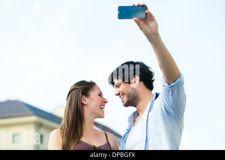 Mann und Frau oder junge Paar Reise als Tourist in München zu machen und Snapshot mit dem Smartphone oder Handy Stockfoto