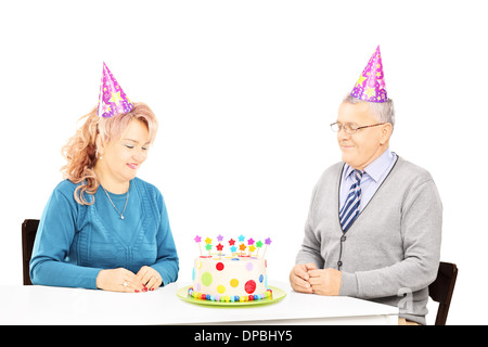 Mittleren gealterten paar sitzt auf Geburtstagsparty Blick auf Kuchen Stockfoto