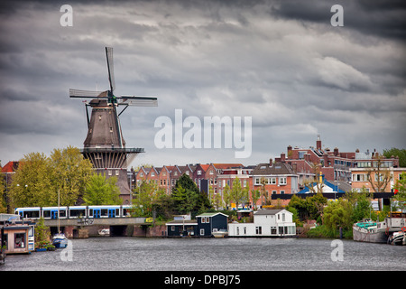 Die Gooyer Windmühle und Häuser durch den Kanal, die Stadt von Amsterdam, Nordholland, Niederlande. Stockfoto