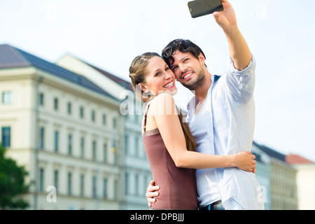 Mann und Frau oder junge Paar Reise als Tourist in München zu machen und Snapshot mit dem Smartphone oder Handy Stockfoto