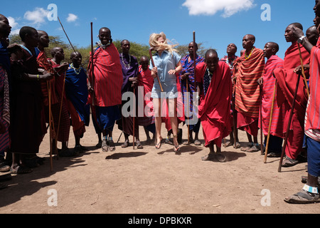 Ein junger Tourist tanzen mit Massai-Krieger in der Ngorongoro Conservation Area im Krater Hochland von Tansania Afrika Stockfoto