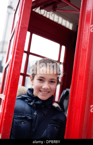 Junges Mädchen in einem roten Telefon Hütte in London, Großbritannien Stockfoto