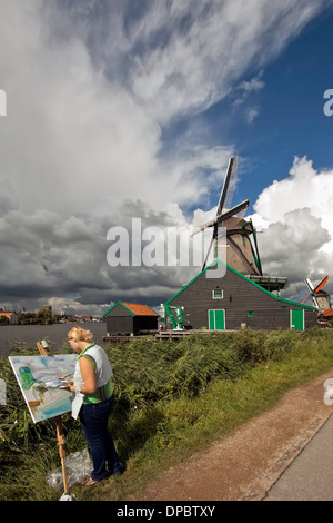 Künstler malen unter einem bedrohlichen Himmel in Zaanse Schans, Zaandam, Nordholland, Niederlande. Stockfoto