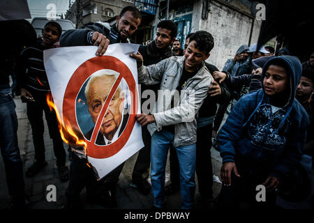 Gaza, Palästinensische Gebiete. 13. Januar 2014. Palästinensische Jugendliche brennen Bilder, für die ehemaligen israelischen Ministerpräsidenten Ariel Sharon und verteilen von Süßigkeiten zu feiern ein nach der Ankündigung seines Todes in Khan Younis im südlichen Gazastreifen am 11. Januar 2014. Der Direktor des Krankenhauses, israelischer Professor '' Tal Hashomer'' '' Zeev Rotstein'' am Samstag den Tod des ehemaligen Ministerpräsidenten Ariel Sharon nach seinem Kampf mit dem Tod und Koma im Koma seit acht Jahren. Bildnachweis: Ari Rahim Khatib/NurPhoto/ZUMAPRESS.com/Alamy Live-Nachrichten Stockfoto