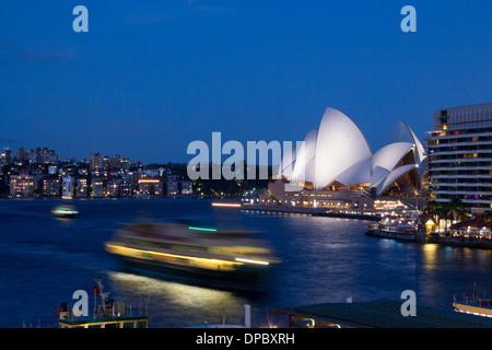 Circular Quay in der Dämmerung Nacht Dämmerung mit Fähre anreisen und das Opernhaus in Sydney New South Wales NSW Australia Hintergrund Stockfoto