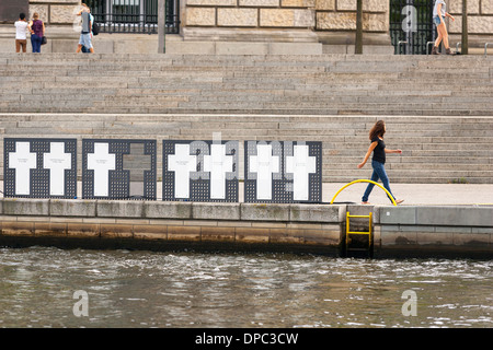 Eine Frau pass in der Nähe der "Weisse Kreuze" Gedenkstätte für die Opfer der Berliner Mauer. Bundestag. Berlin. Deutschland. Stockfoto