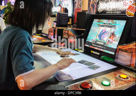 Mann, spielt Videospiele auf eine komplizierte Maschine, Hiroshima, Japan, Asien. Stockfoto