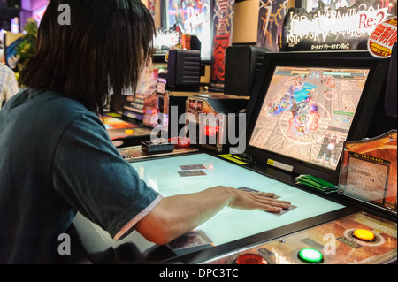 Mann, spielt Videospiele auf eine komplizierte Maschine, Hiroshima, Japan, Asien. Stockfoto