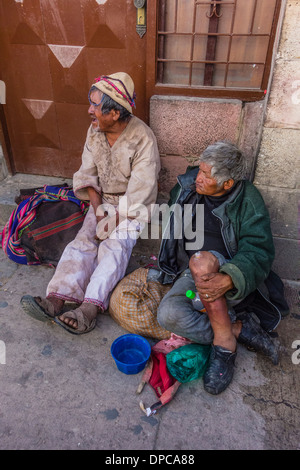 Zwei einheimische männlichen Bettler sitzen auf dem Bürgersteig betteln in Sucre, Bolivien. Stockfoto