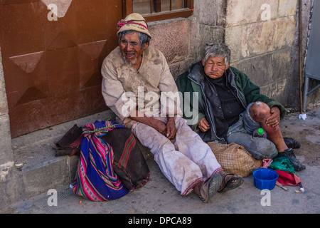 Zwei einheimische männlichen Bettler sitzen auf dem Bürgersteig betteln in Sucre, Bolivien. Stockfoto