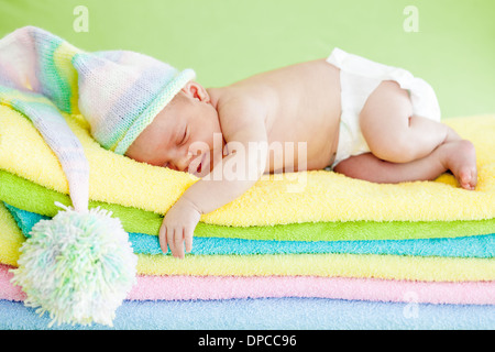 Neugeborenes Babymädchen schläft auf Farbe Handtücher Stockfoto