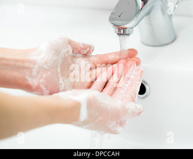 Weibliche Händewaschen mit Seife im Badezimmer hautnah Stockfoto