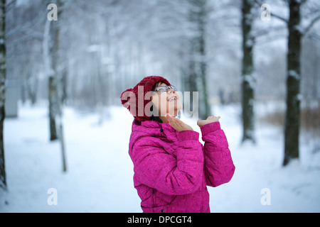 Jung und glücklich Asiatin mit einer rosa Jacke genießt schneit Stockfoto
