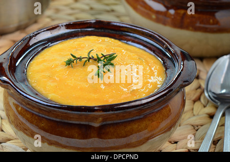 Hausgemachte Möhrensuppe mit Thymian garnieren in rustikalen Suppenschüssel Stockfoto